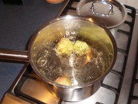 Boiling peaches to blanch them.